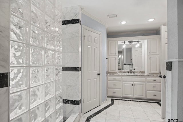 bathroom with ceiling fan, vanity, a tile shower, and ornamental molding