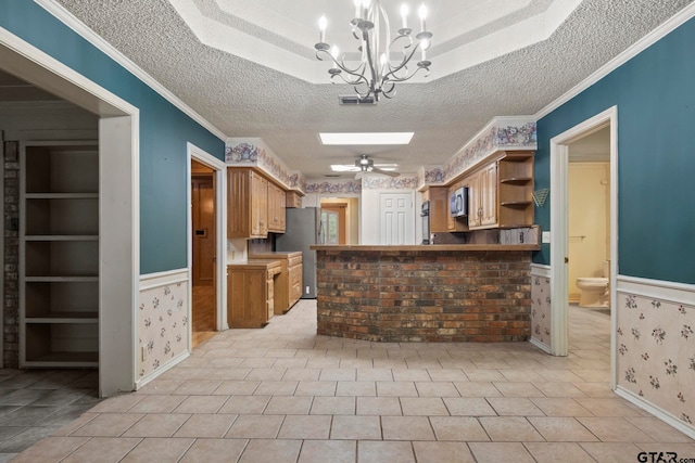 kitchen featuring ceiling fan with notable chandelier, a textured ceiling, light tile patterned flooring, appliances with stainless steel finishes, and built in features