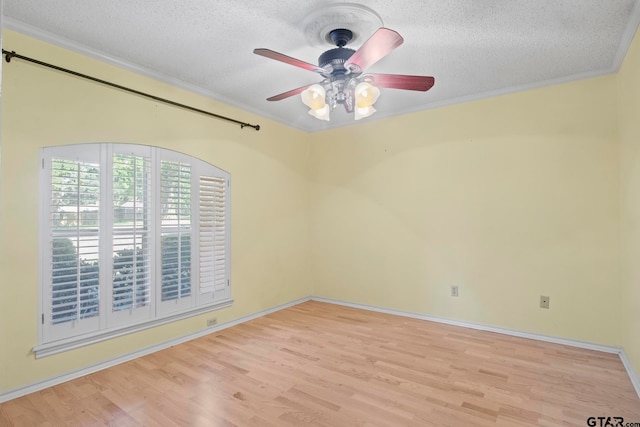 spare room featuring ornamental molding, light hardwood / wood-style floors, a textured ceiling, and ceiling fan