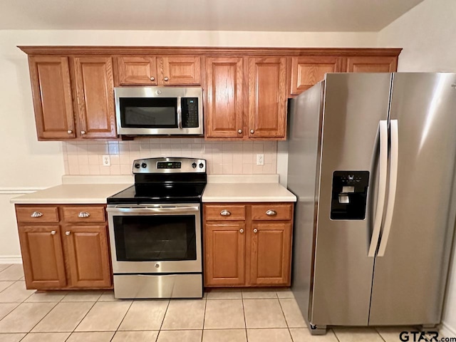 1521 Rice Rd Unit Z103, Tyler, TX 75703 - kitchen featuring stainless steel appliances, brown cabinets, light countertops, and light tile patterned floors