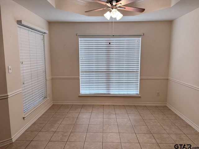 1521 Rice Rd Unit Z103, Tyler, TX 75703 - unfurnished dining area with ceiling fan, light tile patterned floors, a tray ceiling, and baseboards