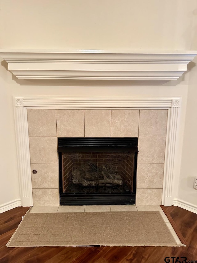 1521 Rice Rd Unit Z103, Tyler, TX 75703 - detailed view of wood finished floors, a tile fireplace, and baseboards