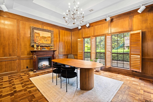 6307 Shady Oaks Dr, Tyler, TX 75703 - dining room with a chandelier, a tray ceiling, a fireplace, wood walls, and track lighting