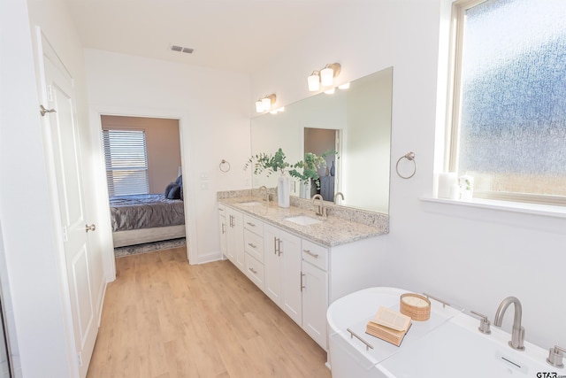 307 Amanda Ave, Bullard, TX 75757 - ensuite bathroom featuring wood finished floors, a freestanding tub, and double vanity