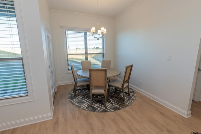 dining space with ornamental molding, light hardwood / wood-style flooring, and a chandelier