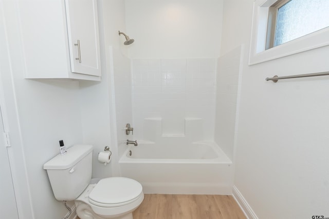 bathroom featuring hardwood / wood-style floors, shower / washtub combination, and toilet