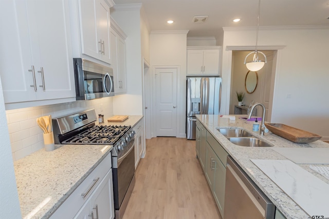 kitchen with stainless steel appliances, sink, crown molding, white cabinetry, and light wood-type flooring