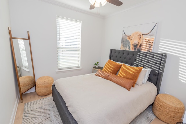 bedroom featuring light hardwood / wood-style floors, ceiling fan, and ornamental molding