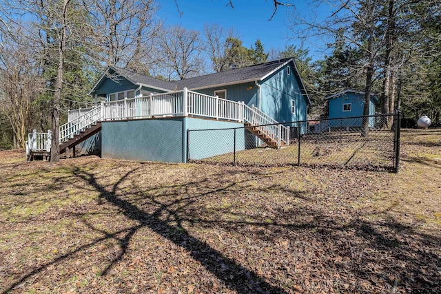 view of side of home with fence, stairway, and a deck