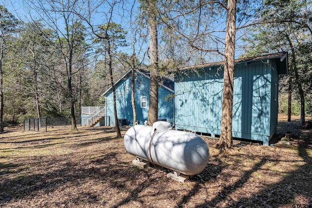 view of side of home featuring fence and an outdoor structure