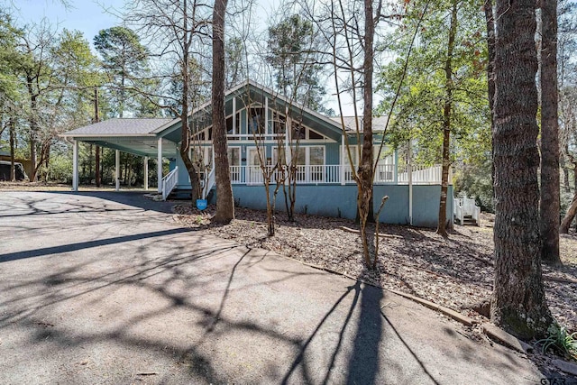 view of front of property featuring covered porch, a carport, and aphalt driveway