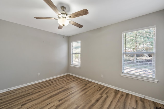 unfurnished room featuring ceiling fan, wood finished floors, and baseboards