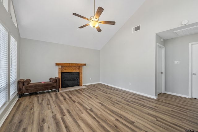 unfurnished living room featuring a fireplace with flush hearth, visible vents, baseboards, and wood finished floors