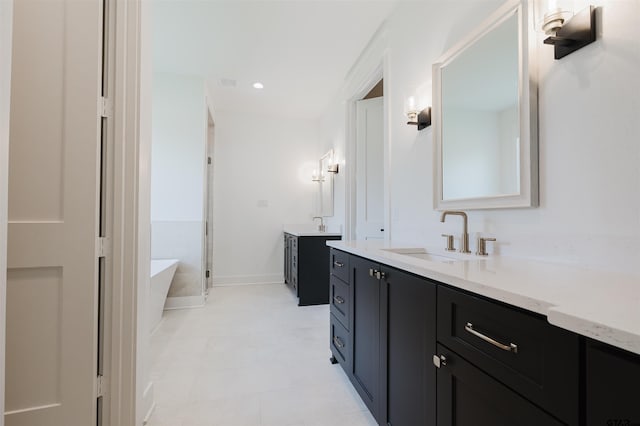 bathroom featuring a sink, baseboards, a freestanding tub, two vanities, and a shower stall