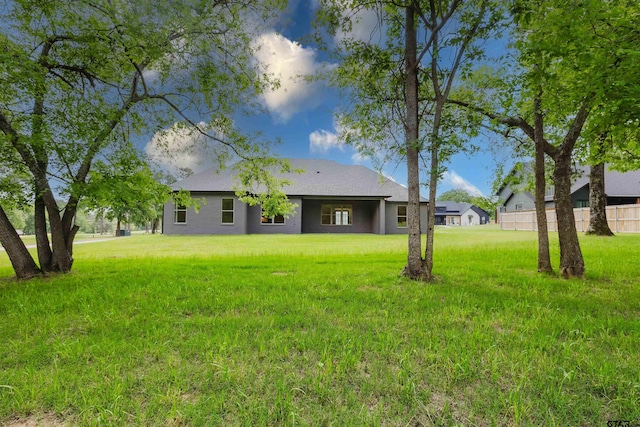 rear view of property featuring a lawn