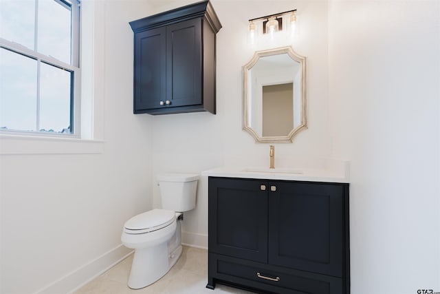 half bath featuring baseboards, tile patterned floors, toilet, and vanity