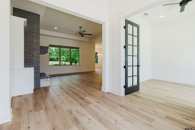 empty room featuring baseboards, a ceiling fan, wood finished floors, and visible vents