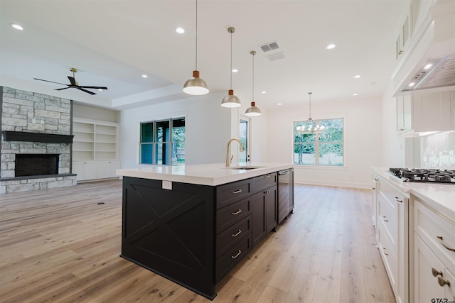 kitchen featuring white cabinets, stainless steel appliances, a sink, and light countertops