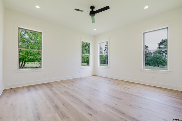 empty room featuring light wood-type flooring, a ceiling fan, baseboards, and recessed lighting