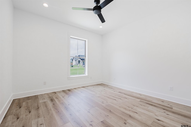 spare room featuring light wood-style floors, baseboards, and ceiling fan