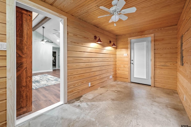 empty room with vaulted ceiling with beams, ceiling fan, concrete flooring, and wooden walls