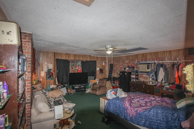 bedroom featuring wood walls, a textured ceiling, ceiling fan, and carpet flooring