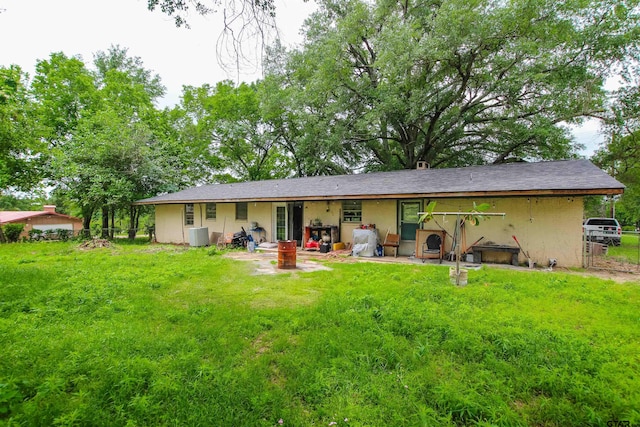 rear view of house with a lawn and fence