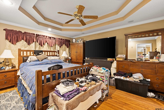 177 Paint Rock Pt, Holly Lake Ranch, TX 75765 - bedroom featuring crown molding, a ceiling fan, light wood-style floors, and a tray ceiling
