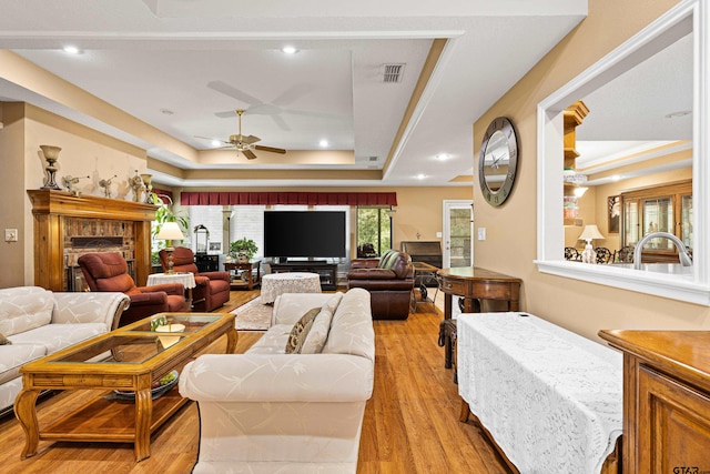 177 Paint Rock Pt, Holly Lake Ranch, TX 75765 - living area with light wood-type flooring, a raised ceiling, ceiling fan, and a fireplace