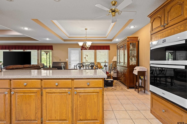 177 Paint Rock Pt, Holly Lake Ranch, TX 75765 - kitchen with brown cabinetry, light countertops, a raised ceiling, double wall oven, and light tile patterned flooring
