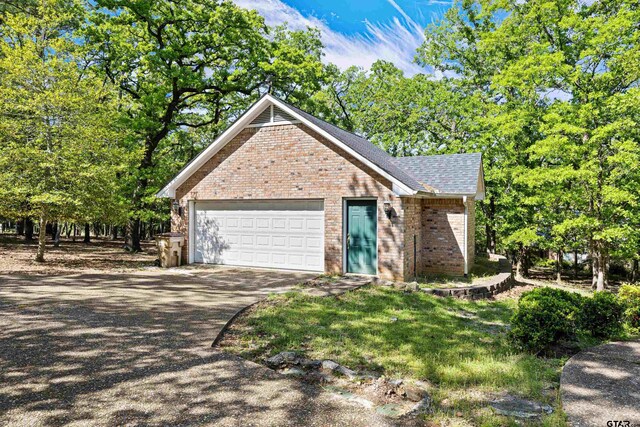 177 Paint Rock Pt, Holly Lake Ranch, TX 75765 - ranch-style house featuring brick siding, a garage, a shingled roof, and concrete driveway