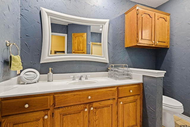 177 Paint Rock Pt, Holly Lake Ranch, TX 75765 - bathroom featuring vanity, a textured wall, tile patterned flooring, and toilet