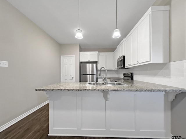 kitchen with sink, white cabinetry, hanging light fixtures, appliances with stainless steel finishes, and kitchen peninsula