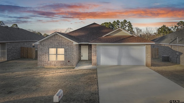 single story home featuring a garage and central air condition unit