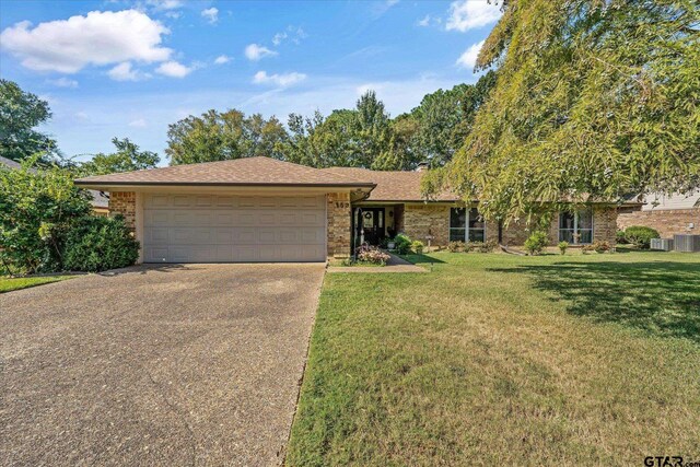 ranch-style home with a garage and a front lawn