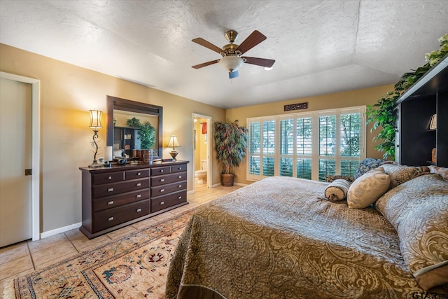 bedroom with connected bathroom, a textured ceiling, light tile patterned floors, and ceiling fan