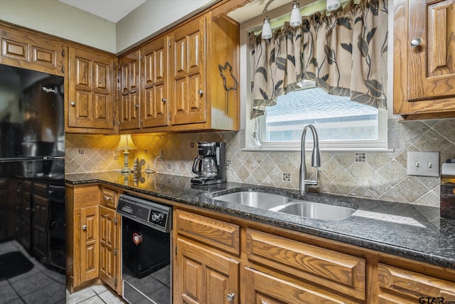 kitchen with sink, tasteful backsplash, dark stone counters, light tile patterned floors, and black dishwasher