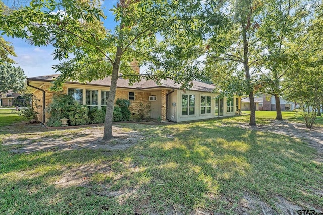 rear view of property featuring a lawn