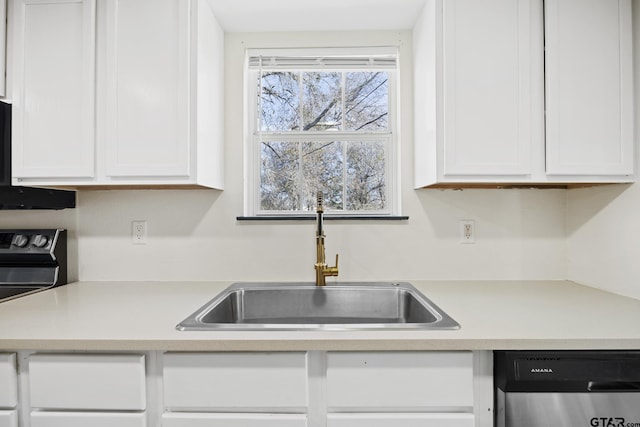 kitchen featuring stainless steel dishwasher, white cabinets, a sink, and light countertops