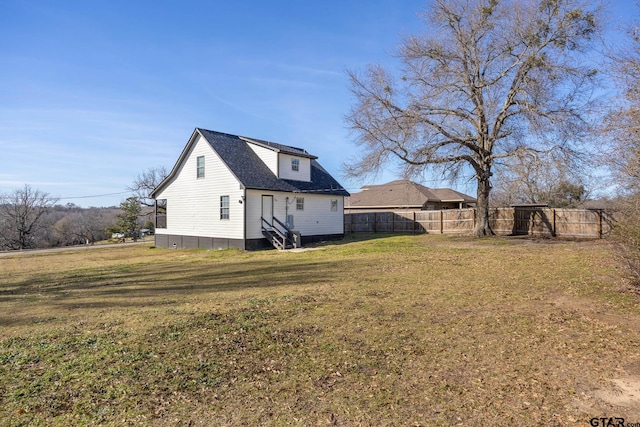 exterior space featuring entry steps, fence, and a lawn