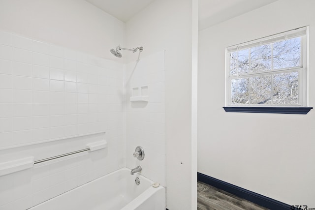 full bathroom with baseboards, wood finished floors, and shower / bathing tub combination