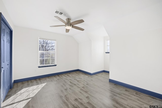 unfurnished room featuring a ceiling fan, baseboards, visible vents, and wood finished floors