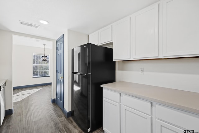 kitchen featuring visible vents, white cabinets, dark wood-style floors, freestanding refrigerator, and light countertops