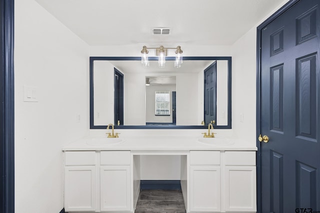 bathroom featuring ceiling fan, visible vents, a sink, and double vanity