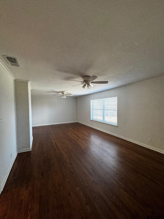 empty room featuring dark wood-style floors, ceiling fan, visible vents, and baseboards