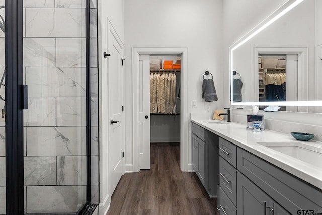 bathroom featuring hardwood / wood-style flooring, vanity, and a shower with shower door