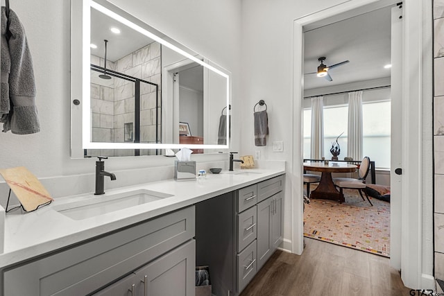 bathroom featuring wood-type flooring, vanity, walk in shower, and ceiling fan