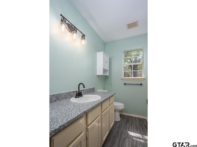 15509 Cedar Bay Dr, Bullard, TX 75757 - bathroom with visible vents, vanity, wood finished floors, toilet, and baseboards