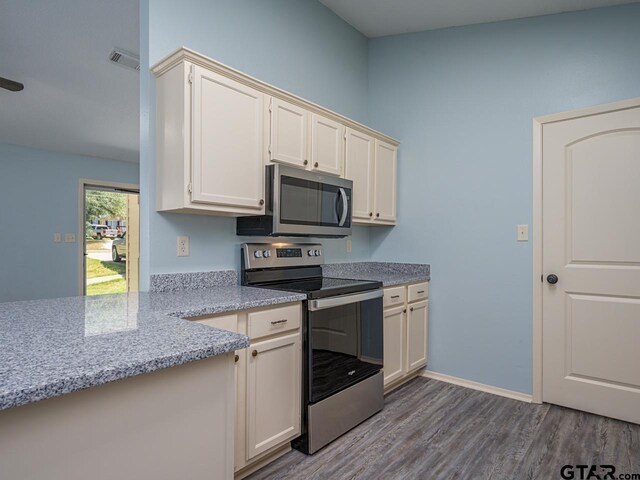 15509 Cedar Bay Dr, Bullard, TX 75757 - kitchen featuring visible vents, baseboards, dark wood-style floors, light stone counters, and stainless steel appliances