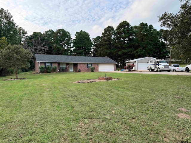 ranch-style home with a front lawn, a garage, and an outbuilding